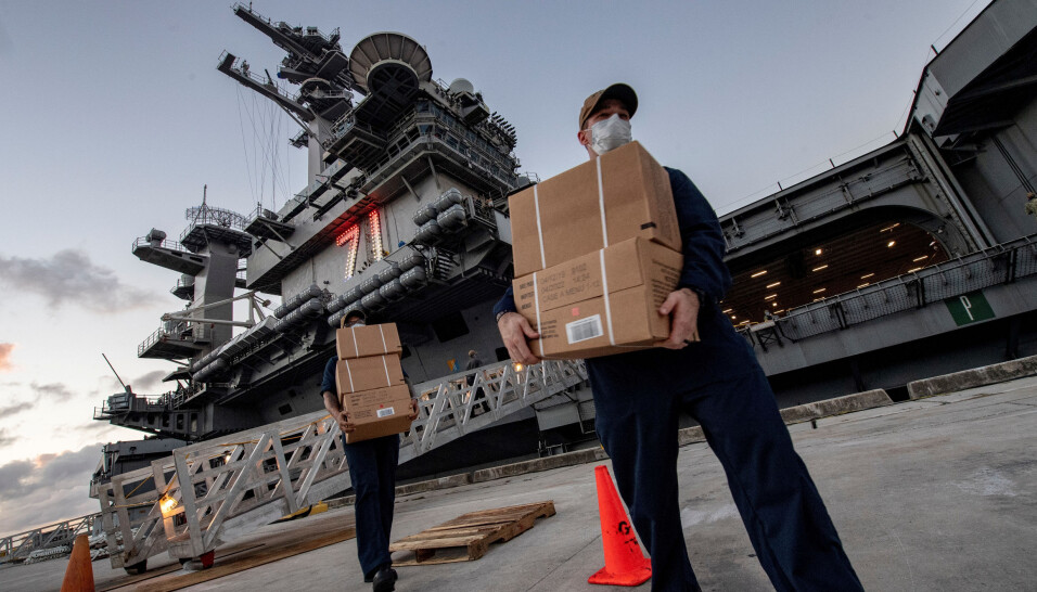 Besetningsmedlemmer ved USS Theodore Roosevelt bærer MRE- måltider til soldatene som har testet negativt for koronaviruset som er i karantene på et lokalt hotell på øya Guam den 7. april 2020.