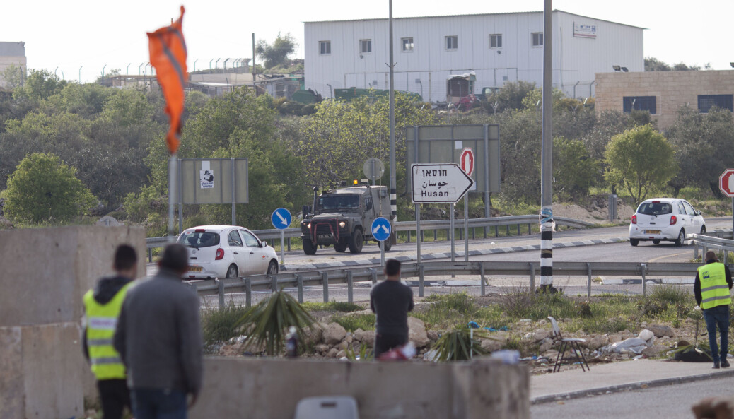 Israelske militærkjøretøy kjører forbi medlemmer av den lokale palestinske nødkomiteen i byen Husan nær Bethlehem. Byen er i ferd med å stenges for å hindre spredning av Covid-19. Israelske militærkjøretøy kjører forbi medlemmer av den lokale palestinske nødkomiteen i byen Husan nær Bethlehem. Byen er i ferd med å stenges for å hindre spredning av Covid-19.