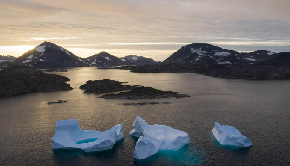 Store isberg flyter i havet i soloppgangen ved Kulusuk på Grønland. USA pumper nå penger inn i bygging av skoler, turisme og råvareindustri på øya. President Donald Trump uttrykte i fjor høst ønske om å kjøpe Grønland, men fikk blankt avslag.
