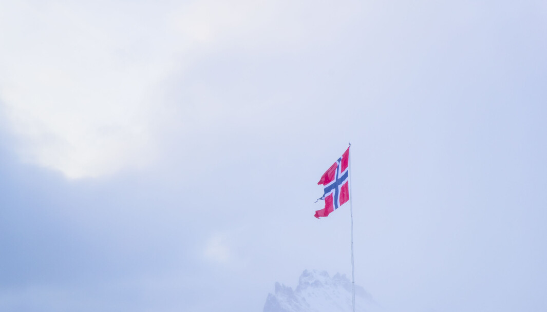 Det norske flagget vaier foran Schiertzegga ved Olonkinbyen på Jan Mayen i februar. Det norske flagget vaier foran Schiertzegga ved Olonkinbyen på Jan Mayen i februar.