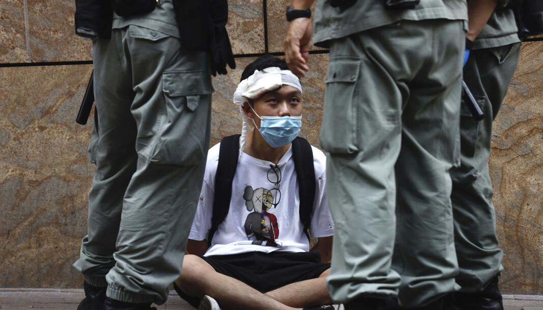 Opprørspoliti omringer en demonstrant i Hongkong etter at en svært kontroversiell sikkerhetslov ble vedtatt av kinesiske myndigheter. Opprørspoliti omringer en demonstrant i Hongkong etter at en svært kontroversiell sikkerhetslov ble vedtatt av kinesiske myndigheter.