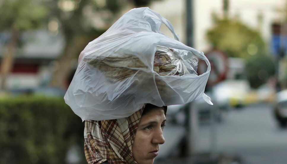 En syrisk kvinne bærer brød på hodet i hovedstaden Damaskus sommeren 2019.