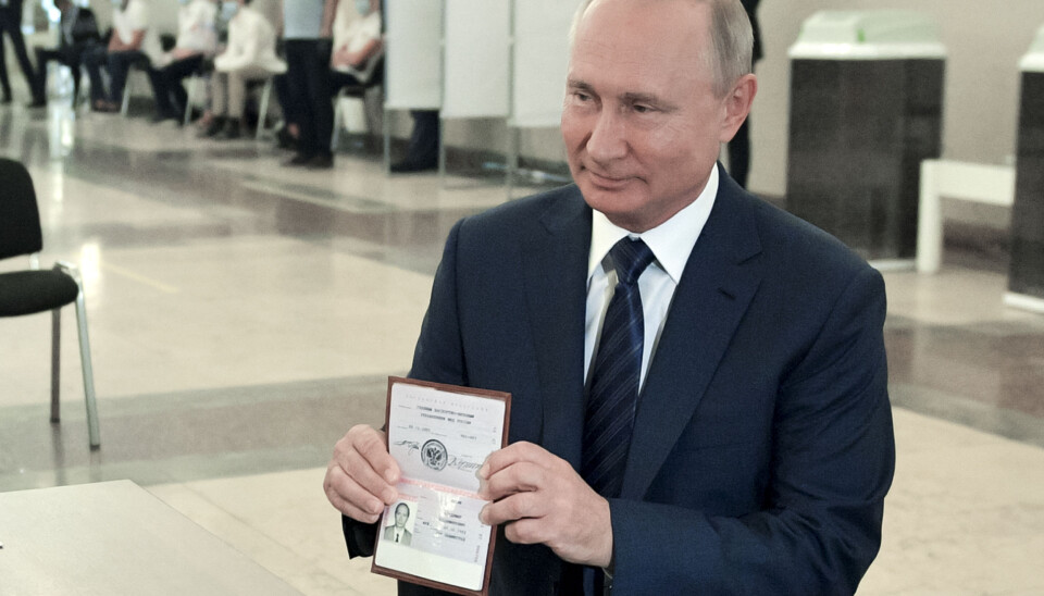 Russlands president Vladimir Putin viser frem passet sitt ved et stemmelokale i Moskva, Russland 1. juli.