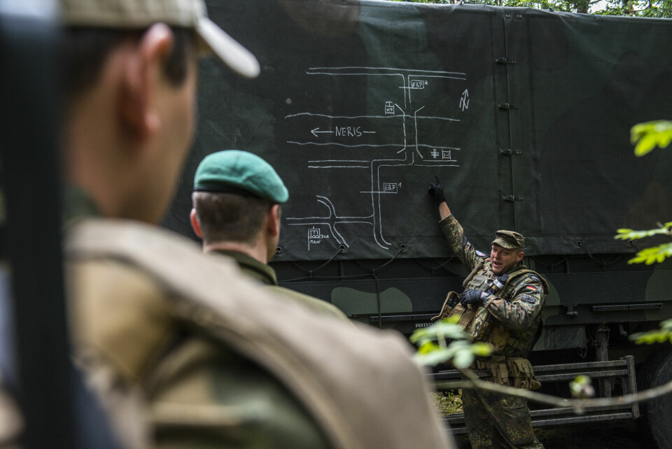 En tysk offiserer gir de norske soldatene en sikkerhetsbrif før elvekrysningen.