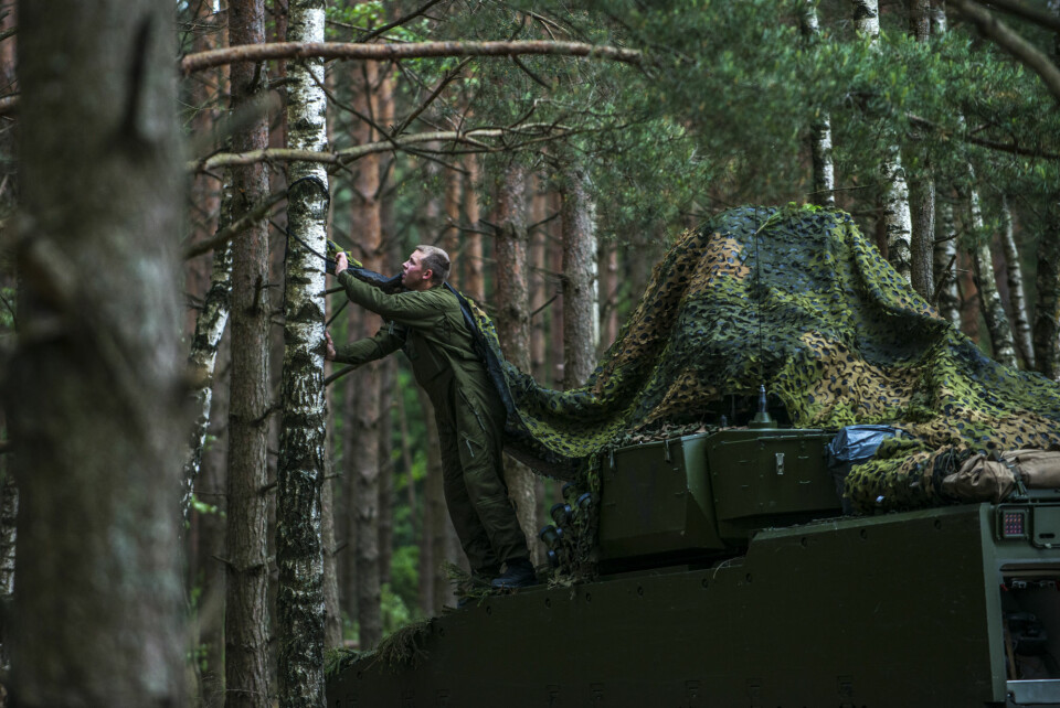 En soldat fra Telemark bataljon kamuflerer vogna til laget. Denne uka sover de i telt eller på panseret til stridsvognene. Den norske styrken holder ellers til i en garnison ved landsbyen Rukla i Litauen.