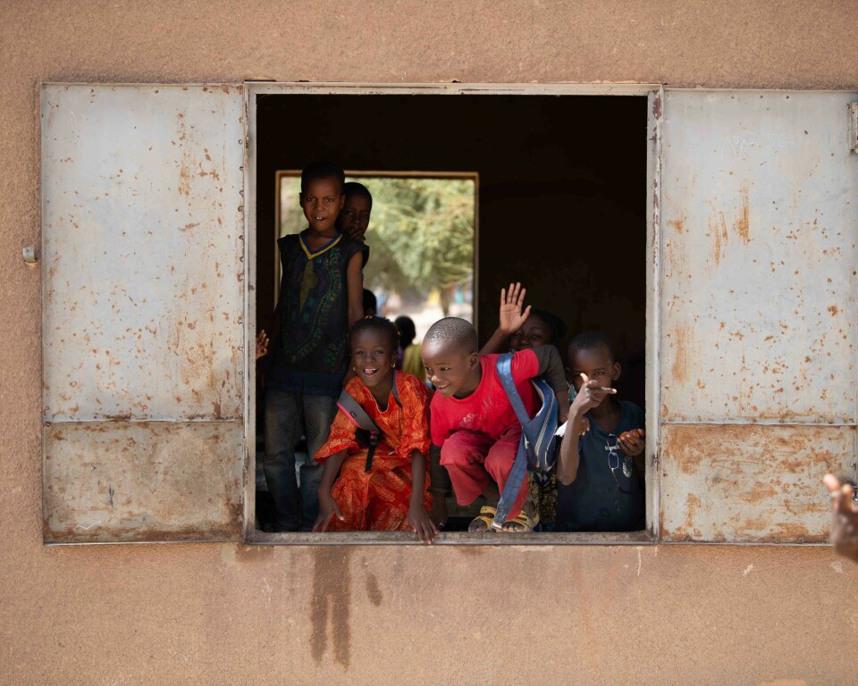 Barn titter ut av skolevinduer idet Forsvarets forum rulser forbi i Timbuktu sentrum. Foto: Silje Kampesæter