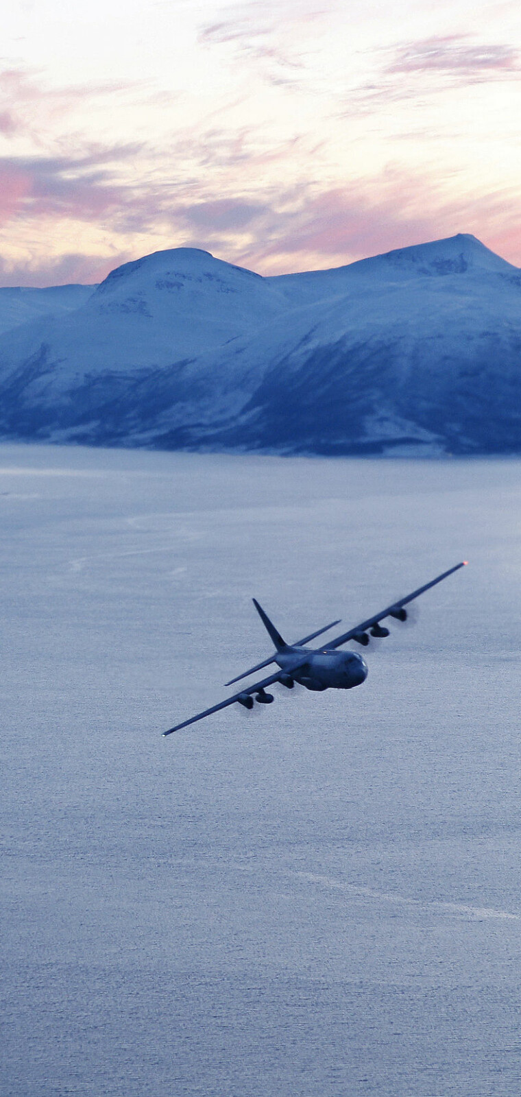 Et norsk Hercules C-130J over en fjord i Nordland under vintervelsen Cold Response 10