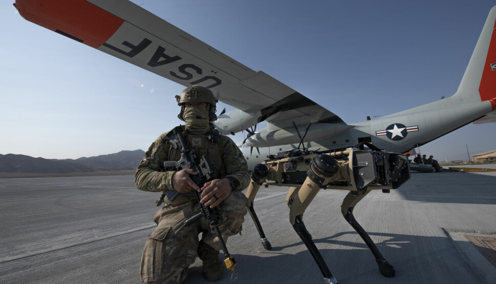 En amerikansk soldat sammen med en «robothund» under en øvelse i Mojave-ørkenen.