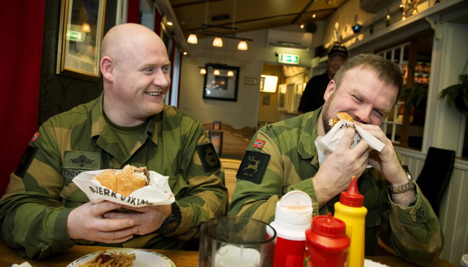 Geir Magne Trøyterud (t.v.) og Oddbjørn Dalsbø setter tennene i hamburgeren som kalles «Bjerkvikingen». Under militærøvelser øker omsetningen betydelig for Det lille kjøkken i Bjerkvik.