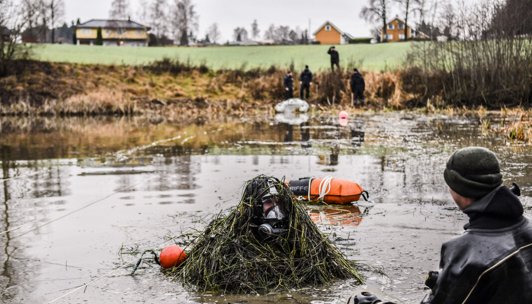 NØKKEN DUKKER OPP: Vannet er fullt av siv og gress, som hekter seg opp i utstyret til operatørene fra MDK. Etterforskere fra Kripos og Øst politidistrikt observerer fra land. NØKKEN DUKKER OPP: Vannet er fullt av siv og gress, som hekter seg opp i utstyret til operatørene fra MDK. Etterforskere fra Kripos og Øst politidistrikt observerer fra land.