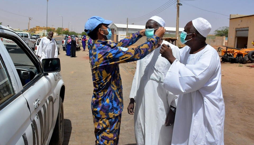 En FN-soldat fra Bangladesh deler ut munnbind i Darfur.
