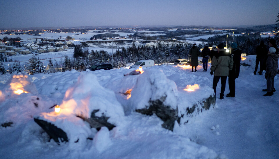 På en høyde med utsikt til rasområdet på Ask i Gjerdrum kommer folk og tenner lys og ser på det enorme området som er omfattet av jordskredet.