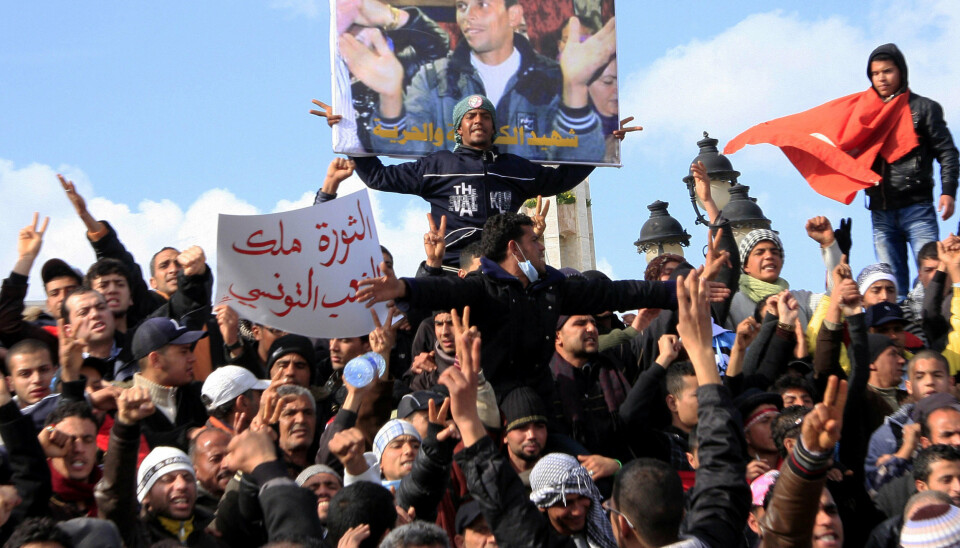 SJASMINREVOLUSJONEN: Demonstranter i Tunisia i januar 2011 foran et bilde av Mohamed Bouazizi, grønnsakshandleren som satte fyr på seg selv.