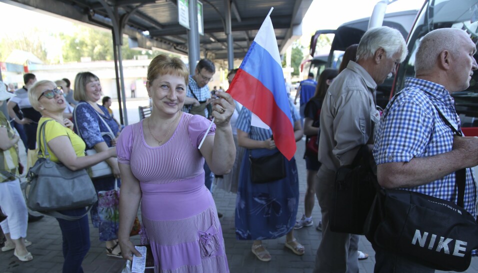 STATSBORGERSKAP: Russland har gitt russisk statsborgerskap til mange av innbyggerne i Donetsk. Denne kvinnen vifter med et russisk flagg, på veit til Russland for å stemme i folkeavstemningen endringer i den russiske grunnloven.