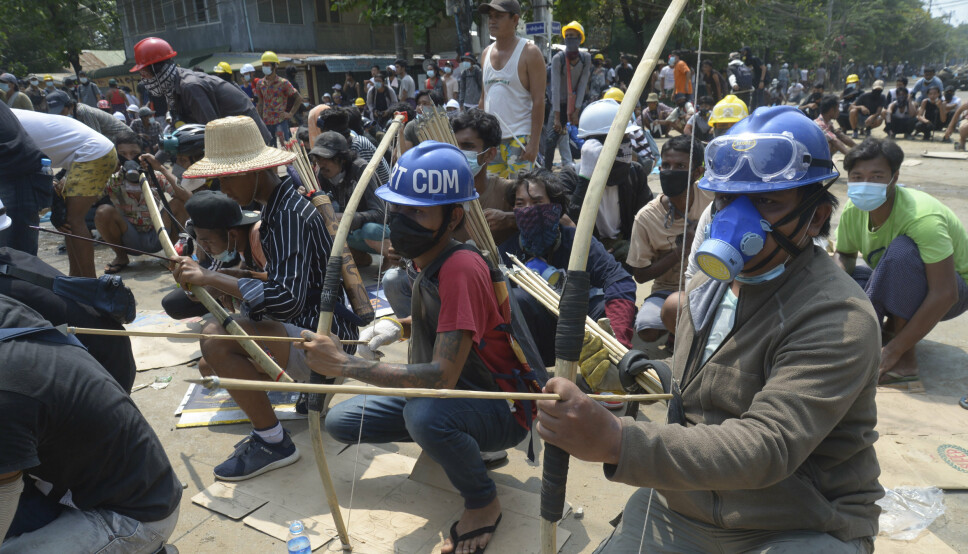 Kuppmotstandere væpnet med pil og bue i en konfrontasjon med politiet i bydelen Thaketa i Myanmar lørdag.