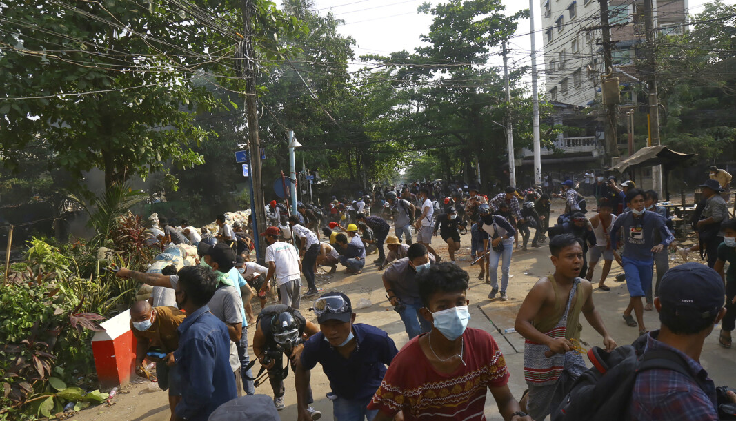 Opprørspoliti bryter opp en folkemengde i Yangon i Myanmar søndag. Opprørspoliti bryter opp en folkemengde i Yangon i Myanmar søndag.