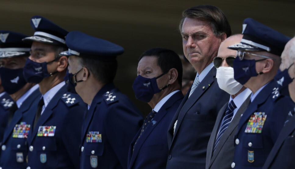 HODENE RULLER: President Jair Bolsonaro, uten munnbind, flankert av visepresident Hamilton Mourao, til venstre, og Fernando Azevedo, som inntil i går var Brasils forsvarsminister. Her deltar de på en markering for det brasilianske luftforsvarets 80-årsjubileum i januar i år.