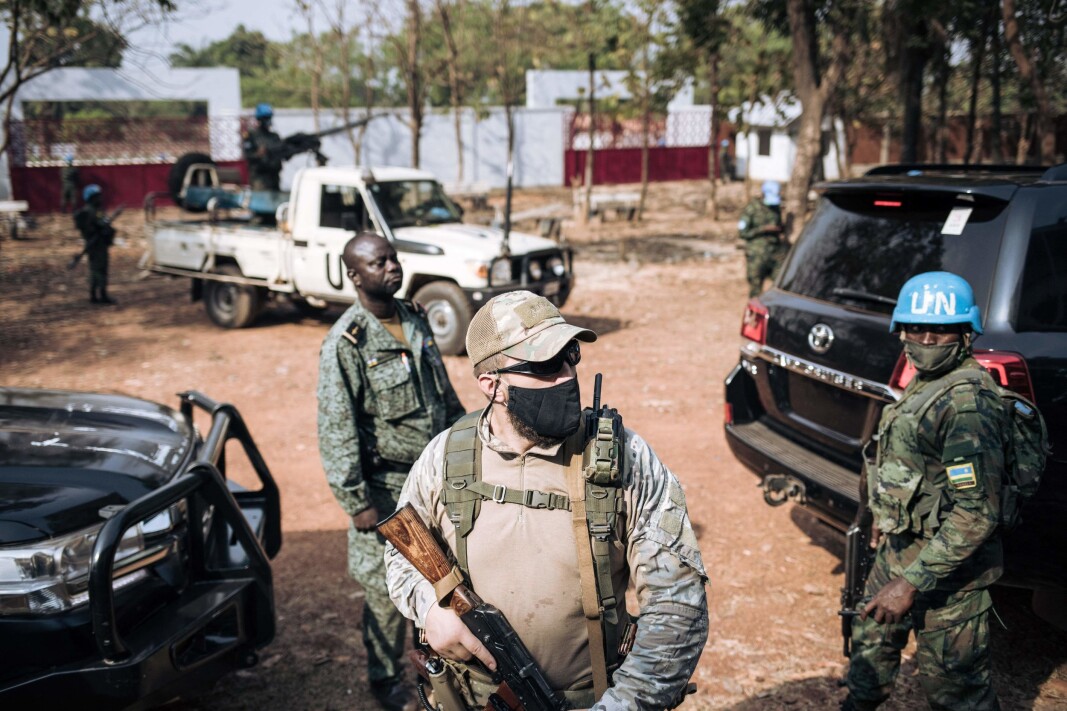 RUSSISK SIKKERHETSSELSKAP: En rwandisk FN-soldat tilhørende MINUSCA, et medlem av den sentralafrikanske presidentgarden og en russisk soldat fra et privat sikkerhetsselskap står vakt utenfor et valglokale i Bangui 27. desember 2020, mens president Faustin Archange Touadera avlegger sin stemme. RUSSISK SIKKERHETSSELSKAP: En rwandisk FN-soldat tilhørende MINUSCA, et medlem av den sentralafrikanske presidentgarden og en russisk soldat fra et privat sikkerhetsselskap står vakt utenfor et valglokale i Bangui 27. desember 2020, mens president Faustin Archange Touadera avlegger sin stemme.