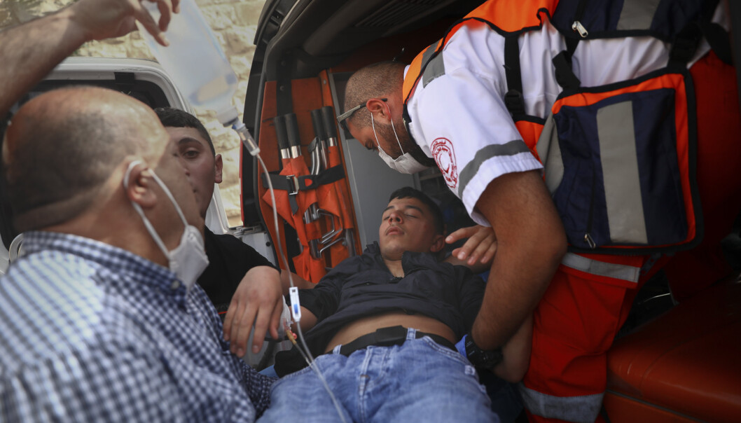 SKADET: En skadd palestiner blir tatt hånd om av ambulansepersonell. SKADET: En skadd palestiner blir tatt hånd om av ambulansepersonell.