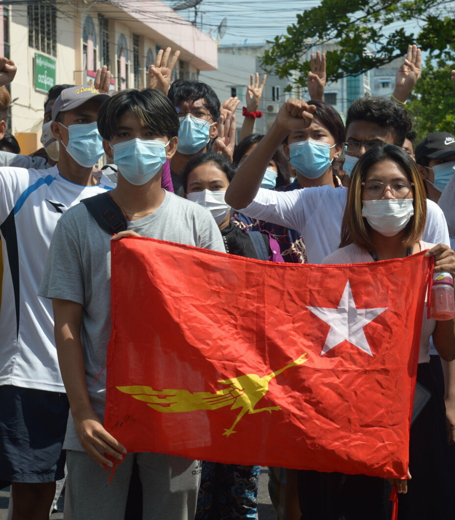 Demonstranter med flagget til partiet Nasjonalligaen for demokrati. Bildet ble tatt i Yangon søndag.