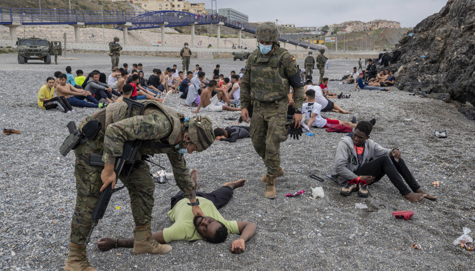 UTSLITT: Spanske soldater hjelper migranter som er utslitt etter å ha svømt rundt en molo fra Marokko til enklaven Ceuta. De fleste av dem blir nå sendt tilbake til Marokko.