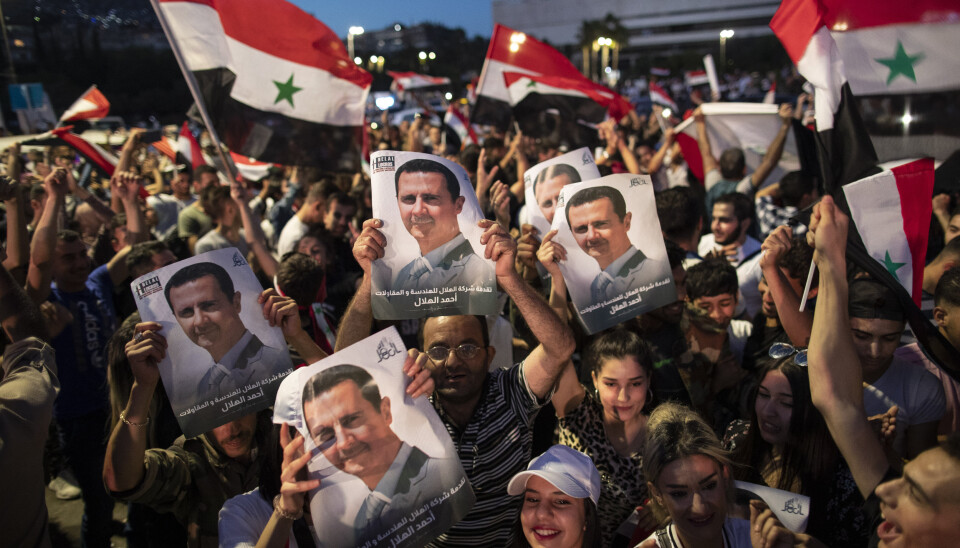 VALGT: Jublende tilhengere av Syrias president Bashar Assad holder opp bilder av sin president etter valget.
