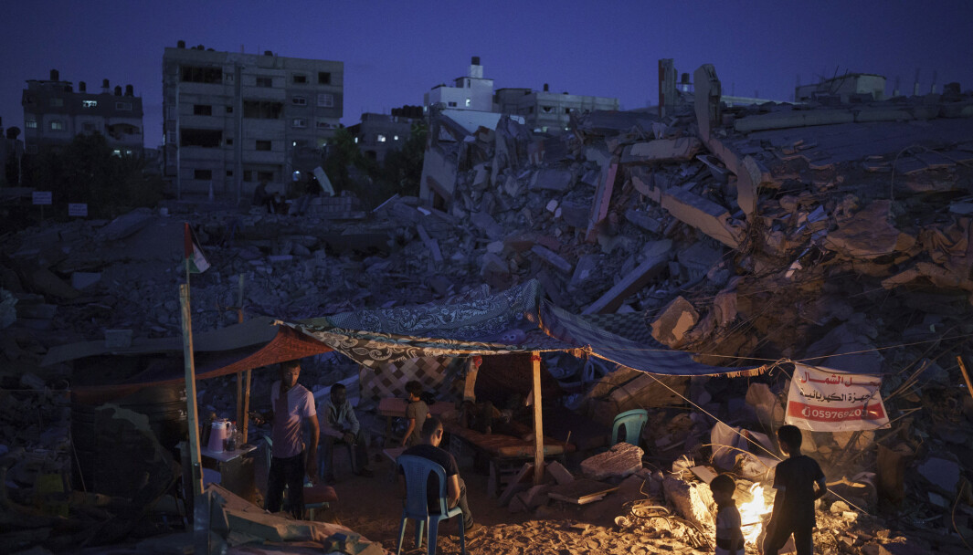 Palestinere sitter inne i et provisorisk telt bygget midt i ruinene til hjemmet deres. Palestinere sitter inne i et provisorisk telt bygget midt i ruinene til hjemmet deres.