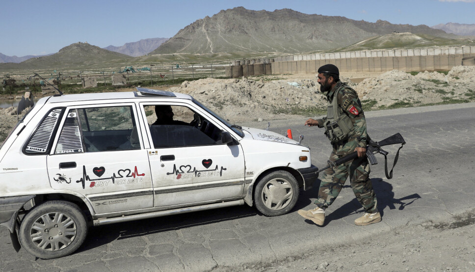 KABUL: En afghansk regjeringssoldat kontrollerer en bil utenfor Kabul. Samtidig rykker Taliban fram i flere distrikter.