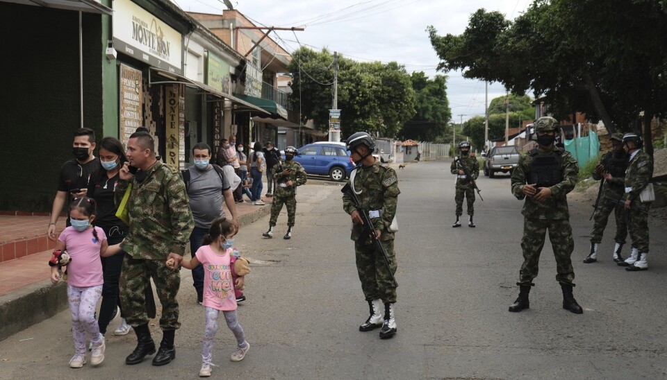 COLOMBIA: En soldat går sammen med familien sin i nærheten av militærbasen som ble rammet av et bombeangrep i Cucuta tirsdag.