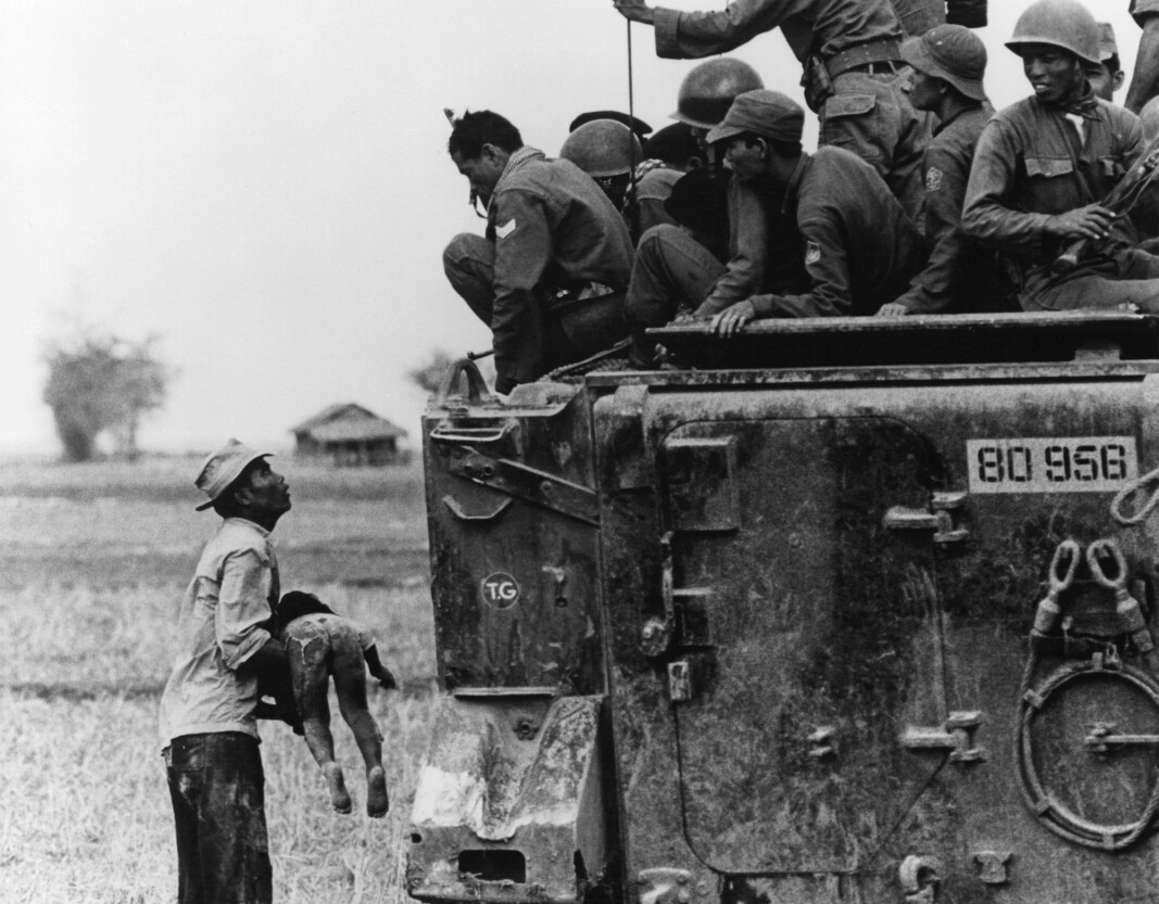 KRIG: En far holder barnet sitt opp mot vietnamesiske soldater under vietnamkrigen 1964. KRIG: En far holder barnet sitt opp mot vietnamesiske soldater under vietnamkrigen 1964.