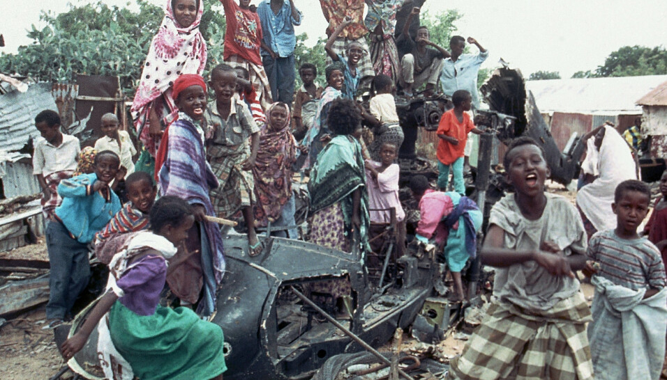 NEDBRENT HELIKOPTER: Unge somaliere sitter på de nedbrente restende av et amerikansk helikopter som styrtet, i oktober 1993, mens de roper slagord for å uttrykke sin motstand mot amerikanerne.