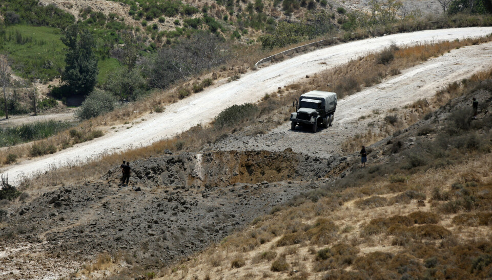 Libanesiske regjeringsstyrker ved et krater forårsaket av et israelsk flyangrep i området Dimashqiya i Sør-Libanon torsdag.