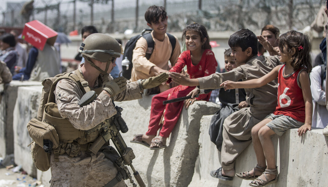 EVAKUERES: En amerikansk soldat leker med en gruppe barn på Hamid Karzai internasjonale lufthavn i Kabul. EVAKUERES: En amerikansk soldat leker med en gruppe barn på Hamid Karzai internasjonale lufthavn i Kabul.