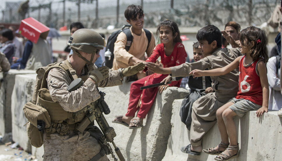 EVAKUERES: En amerikansk soldat leker med en gruppe barn på Hamid Karzai internasjonale lufthavn i Kabul.