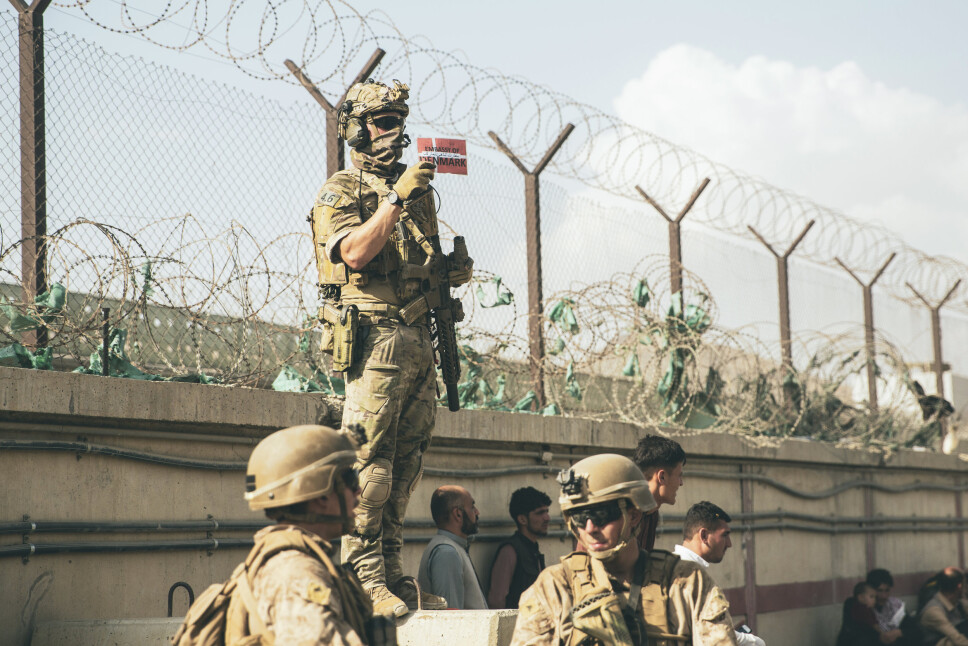 UTTREKNING: En dansk soldat viser frem et dansk flagg slik at aktuelle familier skal finne frem under evakueringsoperasjonen ved Hamid Karzai International Airport i Kabul, Afghanistan tidligere denne uken.