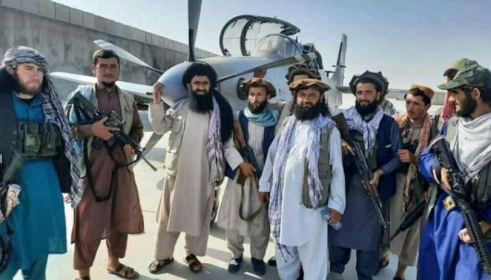 ANGREPSFLY: Medlemmer av Taliban foran et lett angrepsfly som tilhørte det afghanske luftforsvaret.