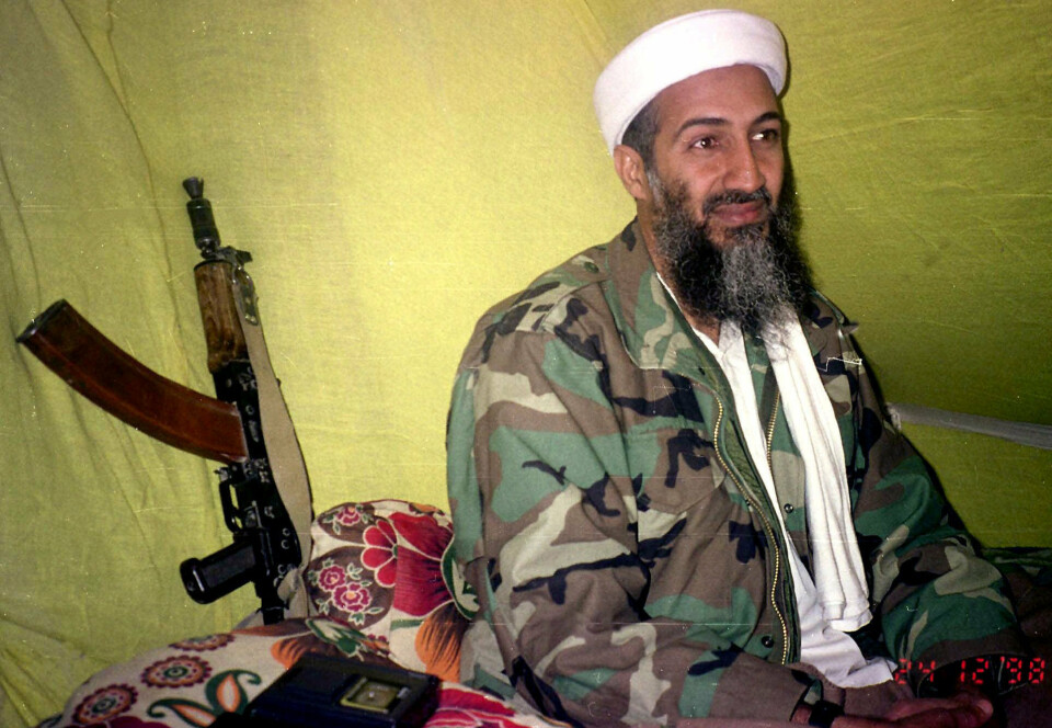 FILE - In this Dec. 24, 1998, file photo, al-Qaida leader Osama Bin Laden speaks to a selected group of reporters in mountains of Helmand province in southern Afghanistan. When the reclusive Islamic State group leader Abu Bakr al-Baghdadi  appeared in a video Monday, he was the latest in a series of most-wanted figures, to use the medium to communicate with the outside world. Al-Baghdadi in his latest video mirrored a picture of Osama Bin Laden in his videos, sitting cross-legged with an assault rifle kept against the wall next to him. (AP Photo/Rahimullah Yousafzai, File)