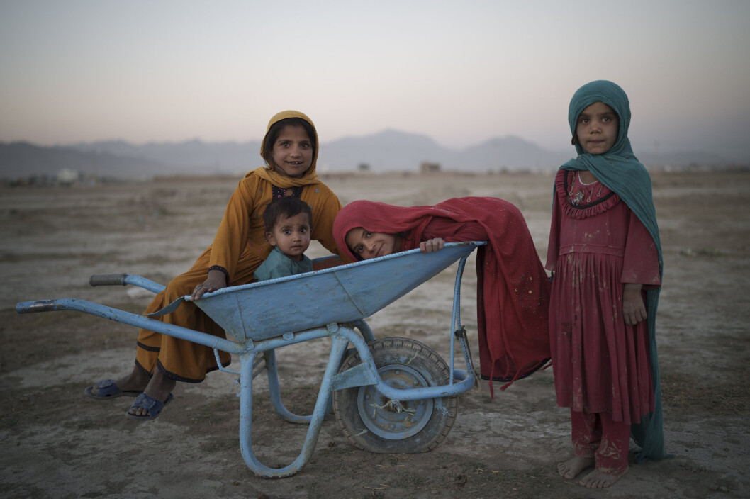 LEIR: Fire barn poserer for fotografen mens de leker i en omplasseringsleir i Kabul. LEIR: Fire barn poserer for fotografen mens de leker i en omplasseringsleir i Kabul.