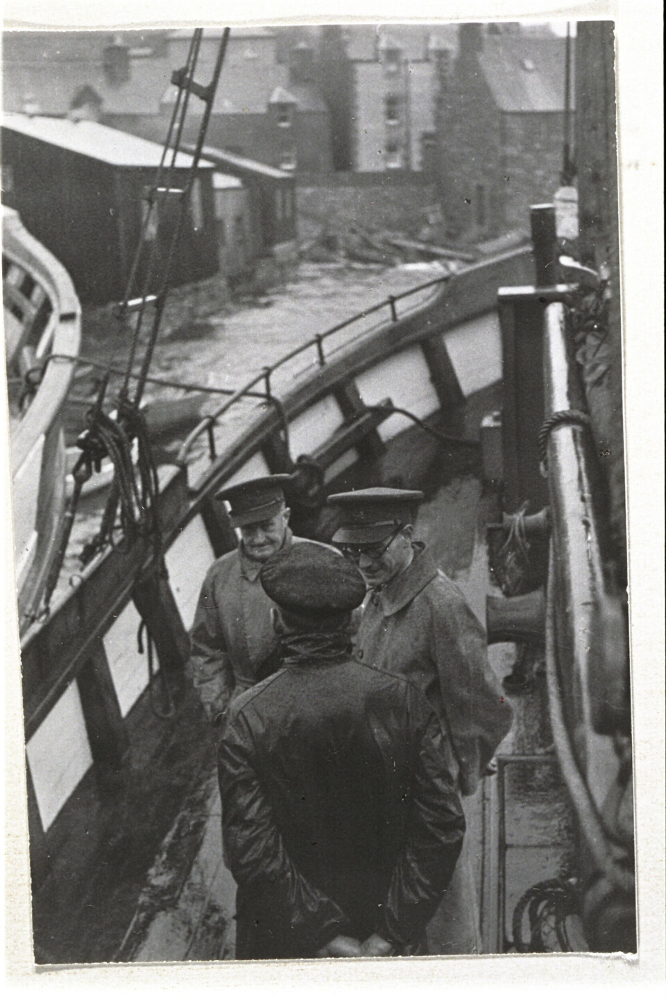 Oberst John Skinner Wilson i samtale med ein av skipperane i Shetlandsgjengen. Wilson leida den norske seksjonen av SOE – Kompani Linge. Ved sida av han står Leslie H. Mitchell, den fyrste sjefen på Shetland, som under åtaket på Noreg var SIS-agent i Oslo.