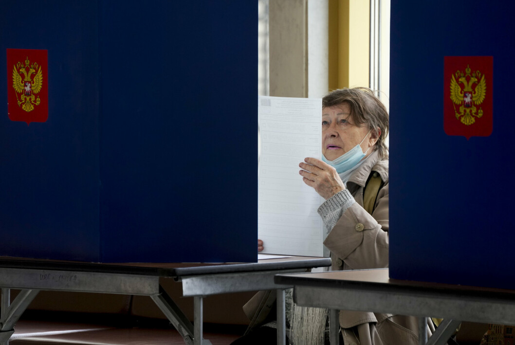 VALG: En kvinne gransker stemmeseddelen på valglokalet i St. Petersburg i Russland lørdag 18. september. EU kritiserer mener valget var preget av trusler mot kritikere av president Vladimir Putin og hans regime.