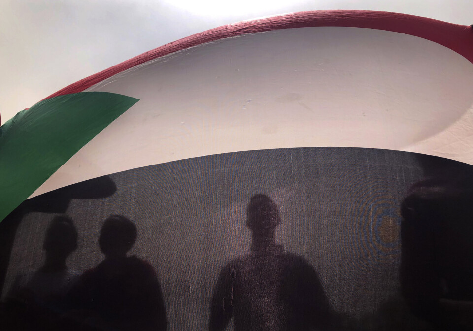 PROTESTERTE: Demonstranter i Sudans hovedstad Khartoum holdt opp et flagg under en protest mot militærregimet i 2019. Tirsdag anklages soldater for å ha stått bak et mislykket kuppforsøk.