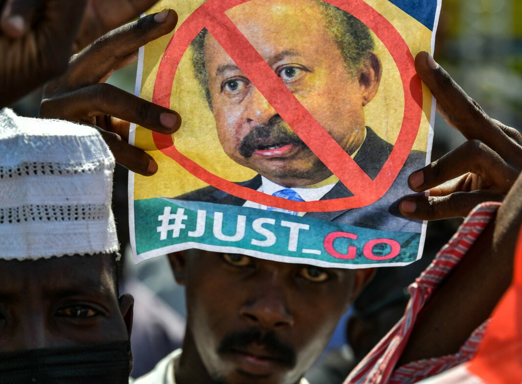 DEMONSTRASJON: En demonstrant holder opp et bilde med president Abdalla Hamdok strøket over under en demonstrasjon utenfor presidentpalasset i Khartoum 21. oktober.
