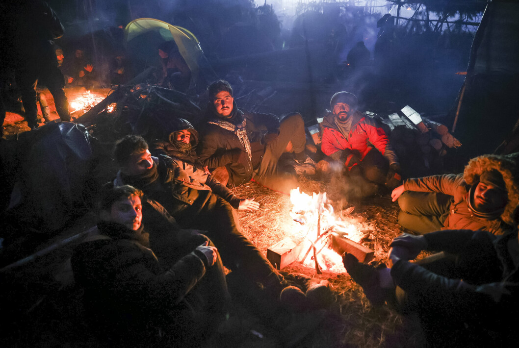 HVITERUSSLAND: Migranter varmer seg på et bål i Grodno i Hviterussland, nær den polske grensen. Hviterussland blir beskyldt for å bruke migranter i hybridkrigføring mot EU.