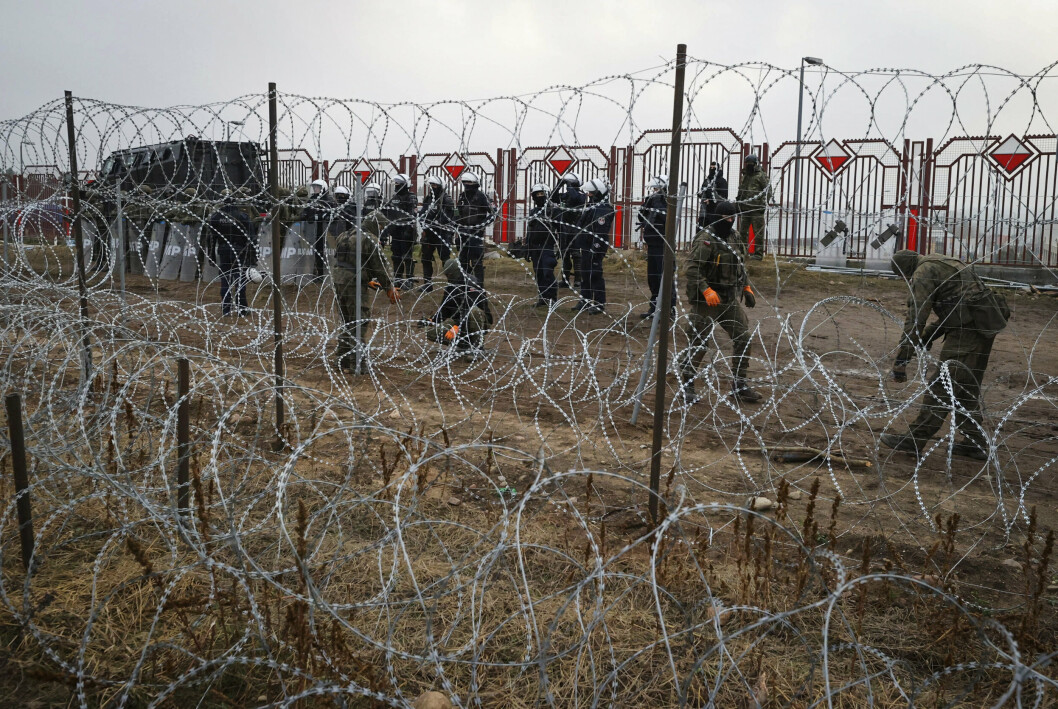 GRENSE: Polsk personell kan skimtes gjennom piggtråden ved grenseovergangen 