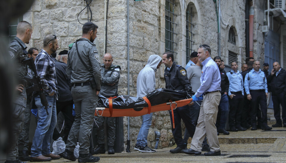 DREPT: Den palestinske mannen som søndag begynte å skyte rundt seg i Øst-Jerusalem, ble selv drept av politiet. Her bæres liket hans vekk.