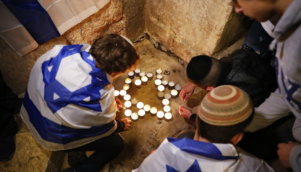 TENTE LYS: Israelsk ungdom tente lys i form av Davidsstjernen på stedet der søndagens angrep fant sted.