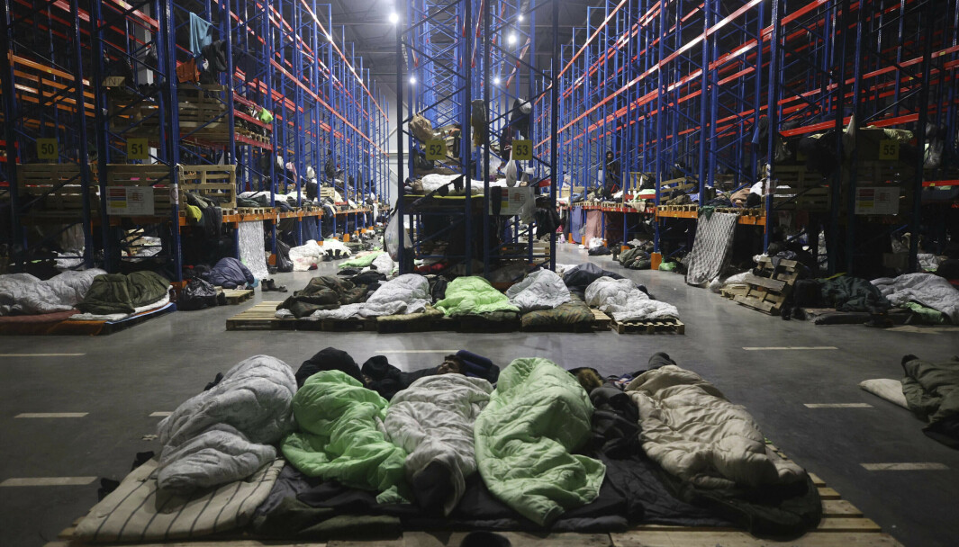 LAGERBYGG: Hviterussland har flyttet migranter fra provisoriske utendørsleirer og inn i denne lagerbygningen nær grensen til Polen. Hviterusslands president Aleksandr Lukasjenko mener EU og Tyskland må ta dem imot. Bildet er tatt mandag. LAGERBYGG: Hviterussland har flyttet migranter fra provisoriske utendørsleirer og inn i denne lagerbygningen nær grensen til Polen. Hviterusslands president Aleksandr Lukasjenko mener EU og Tyskland må ta dem imot. Bildet er tatt mandag.