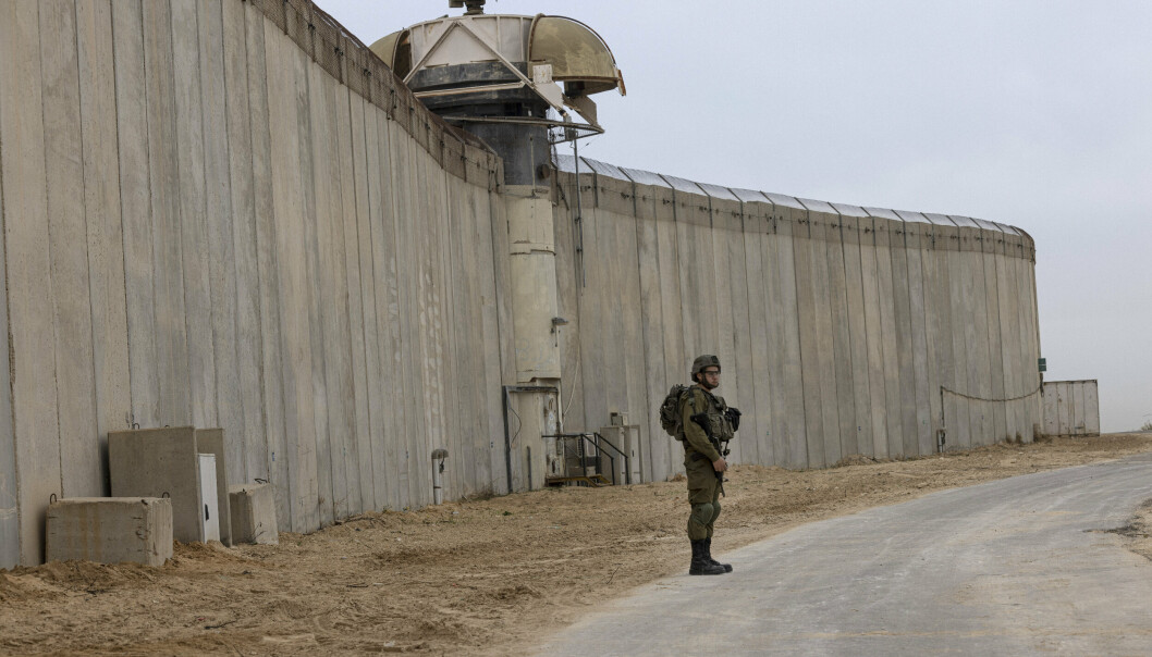 JERNVEGG: En israelsk soldat står vakt ved muren rundt Gaza. Muren er utstyrt med underjordiske sensorer, radar og kameraer for å forebygge trusler, sier Israels forsvarsdepartement. Blant annet skal sensorene kunne oppdage forsøk på å grave under muren.
