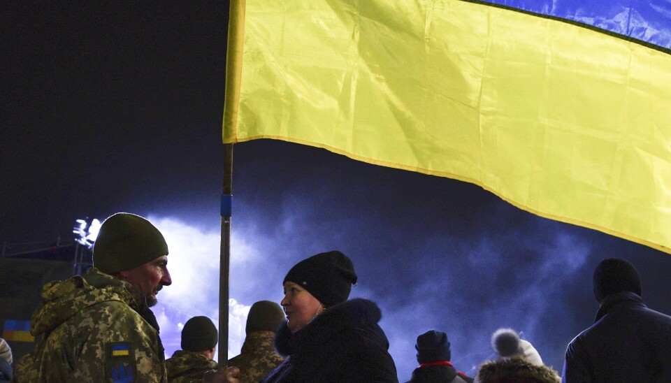 En ukrainsk soldat snakker med en kvinne som holder det ukrainske flagget under en feiring av landets væpnede styrker i Kramatorsk mandag denne uken.
