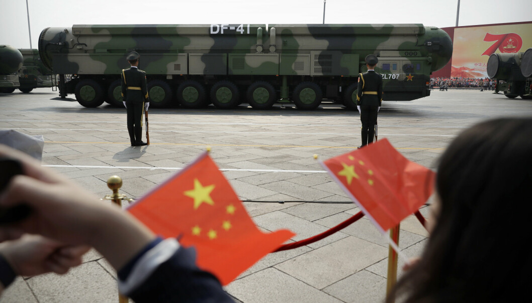 ATOMVÅPEN: Tilskuere viftet med flagg da militære kjøretøy med DF-41 ballistiske missiler, som kan utstyres med atomstridshoder, kjørte forbi på en militærparade i hovedstaden Beijing i oktober 2019.
